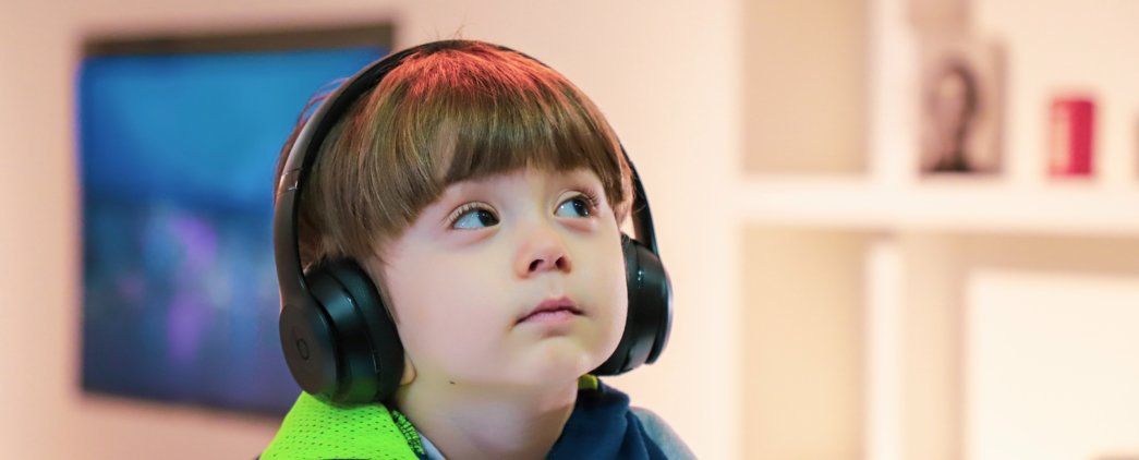 young child with headphones gazing up at an angle