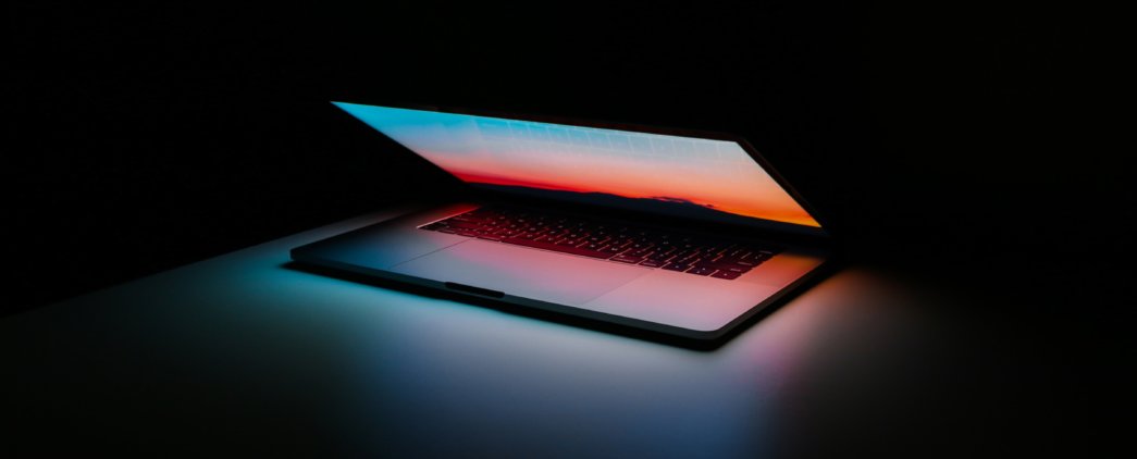 Half open colorful laptop screen set against a black backdrop