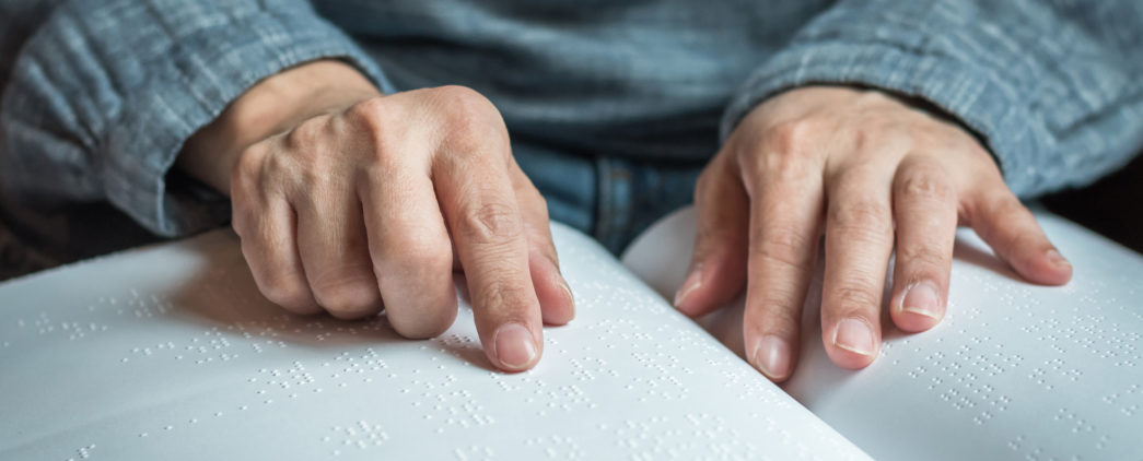 A person reads from a book printed in braille.