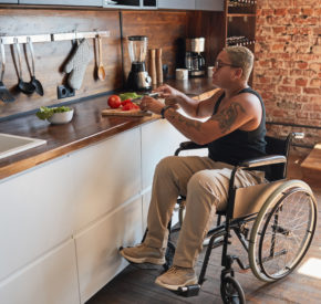 A woman with a disability prepares dinner at home.