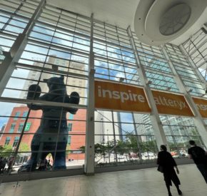 Atrium at the 2022 Alteryx Inspire conference, featuring two attendees and a large bear statue.