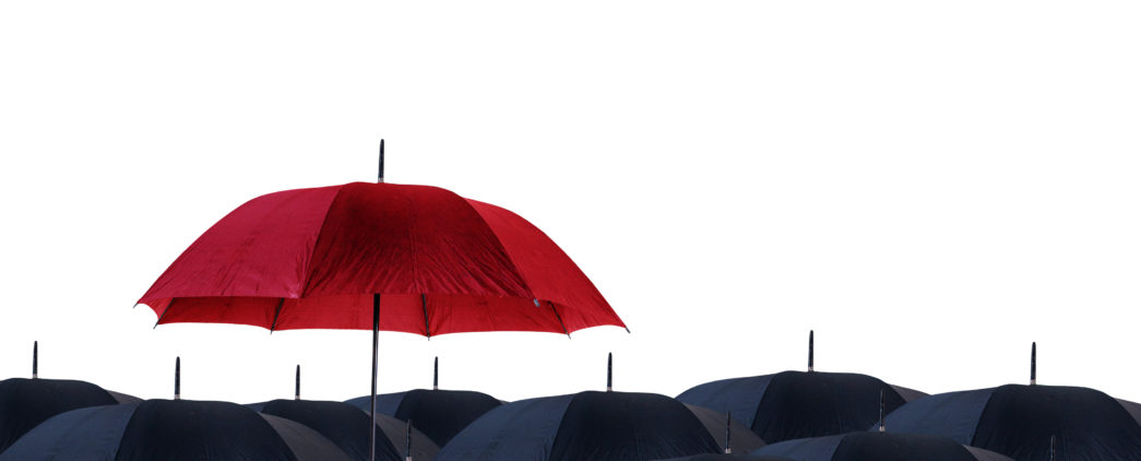 An opened red umbrella held above several open black umbrellas.