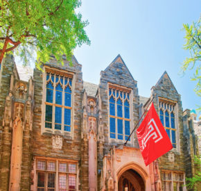 Exterior of a Temple University building, with their flag flying.