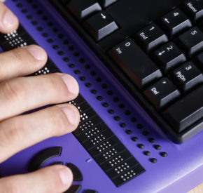 A person who is blind uses a keyboard with a refreshable braille display.