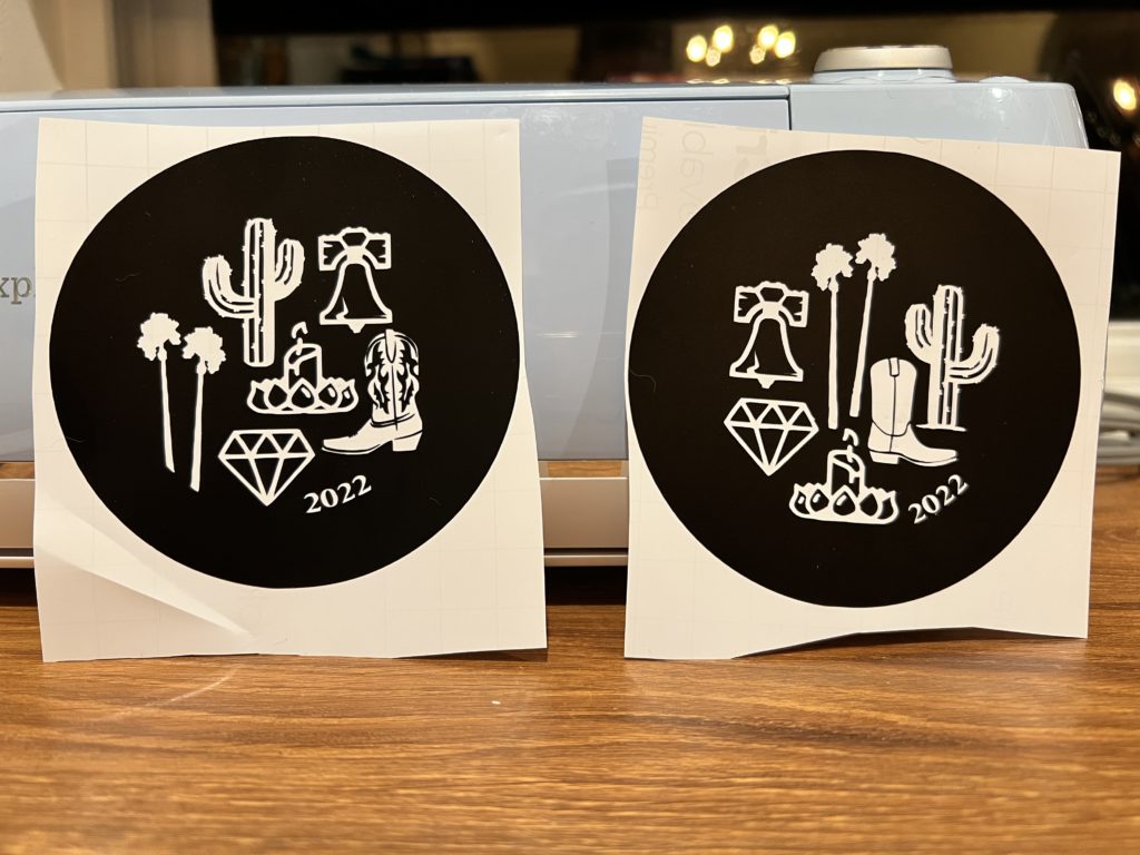 Custom printed black circular stickers with white decals of a cactus, the Liberty Bell, palm trees, a candle, a cowboy boot, a diamond and 2022.