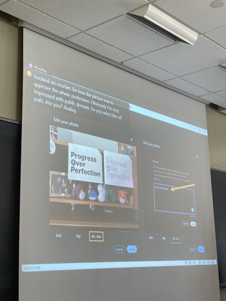 During Meryl Evans’ social media alt text presentation, she showcases her personal desk via a LinkedIn social media post. On her desk are animal plushies, a picture of her family, and the mantra “Progress Over Perfection” written on two sheets of paper. Next to the social media post page is a menu that has the section for entering alt text highlighted.