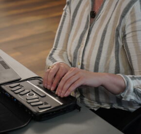 Tamman employee Kristen Witucki uses her braille display in conjunction with her screen reader while attempting to use a website overlay.