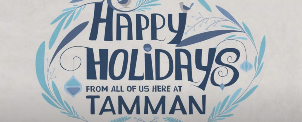 A light and dark blue holiday card graphic reads "Happy Holidays from all of us here at Tamman". The graphic includes lovely bluebirds, branches, rounded ice crystals, and the Tamman "T" logo.