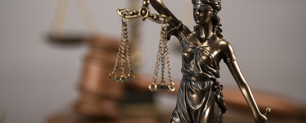 A statue of a blindfolded Lady Justice holding legal scales.