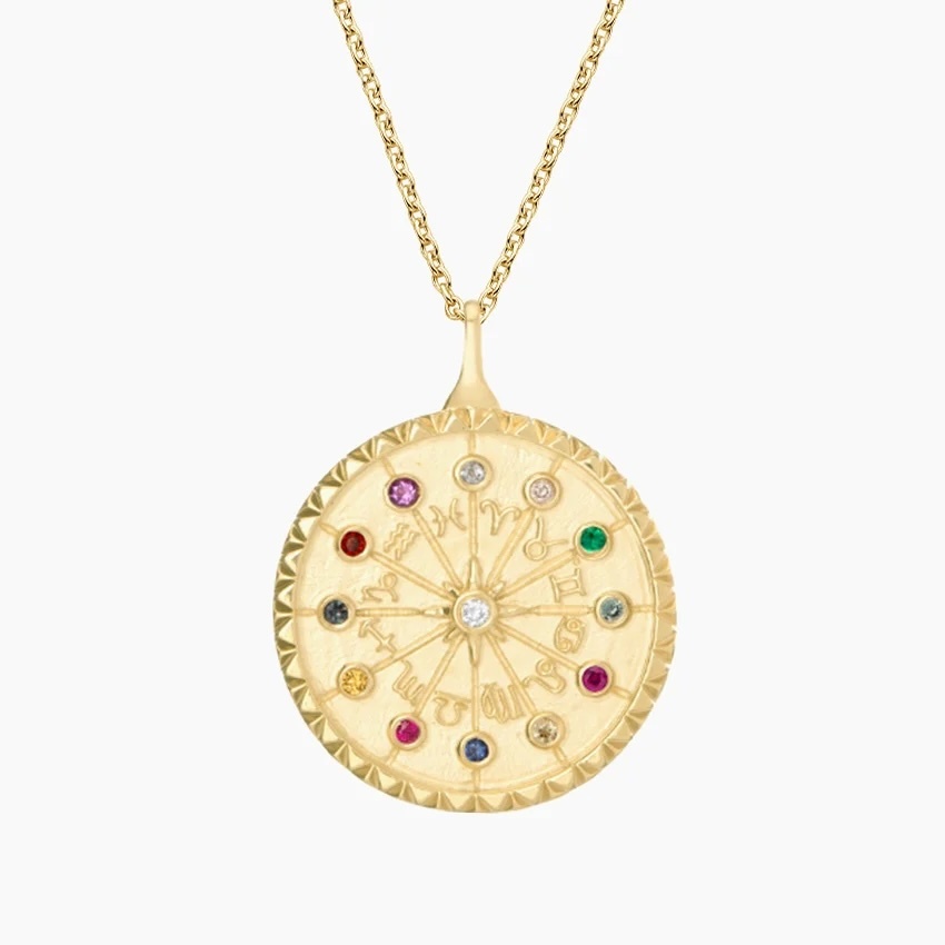 A circular golden pendant on a golden chain. The 12 astrological sign symbols make a smaller circle inside the pendant, and each associated birthstone sits above them.